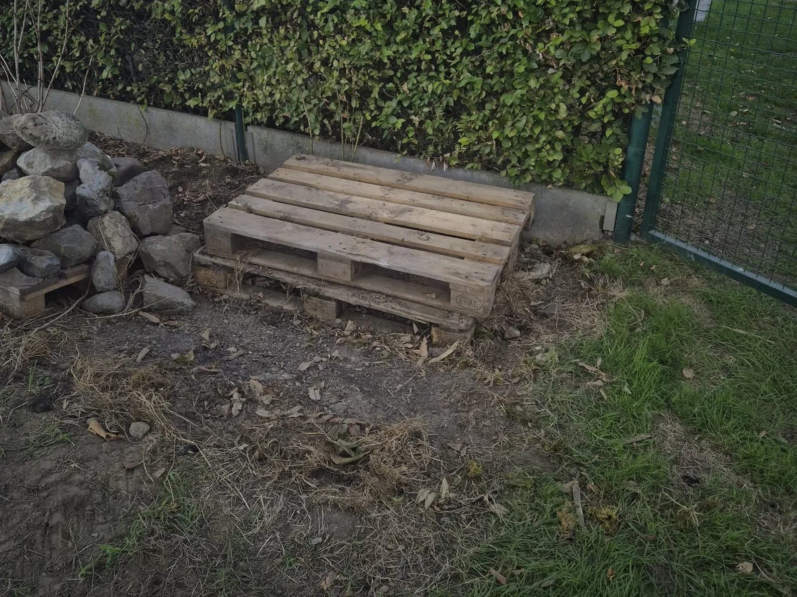 Lege pallet en opgeruimde tuinhoek nadat BR-ontruimingen de natuursteen heeft afgevoerd